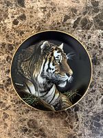 Front of porcelain plate showing Siberian tiger image and gold rim