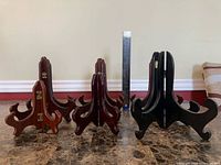 Group of wooden plate holders standing upright for scale comparison