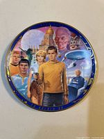 Front view of decorative plate showing artwork and gold rim