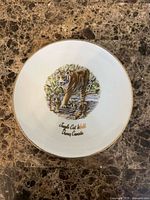 Front of plate showing tiger with cubs illustration, gold rim, text