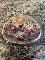 Front view showing tiger and cub image, wood slice shape, bark edge, hanging ribbon