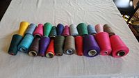 Row of assorted thread cones on table