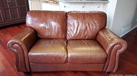 Front view of brown leather loveseat