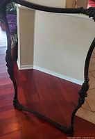 Full view of mirror showing ornate black frame and reflective surface