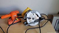 Dewalt circular saw and Black & Decker sander on tabletop