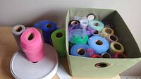 Overview of rolls of tulle and elastic on table and in cube