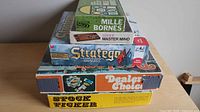 Stack of five vintage game boxes showing titles