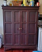 Front view of closed dark wood entertainment cabinet