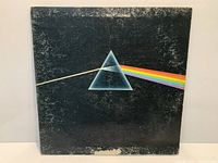 Front cover of Pink Floyd The Dark Side of the Moon LP showing heavy wear and scuffing