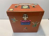 Front view of brown carry case with decals and latch