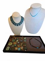 Overall shot of two displayed necklaces and tray of assorted turquoise jewellery pieces