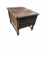 Front angled view showing carved drawer front, pulls, and leg design