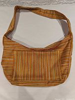 Front view of striped wool-blend shoulder bag showing exterior pocket and strap