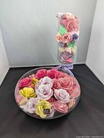 Low glass bowl and pedestal vase filled with paper roses displayed together
