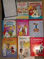 Top view showing nine of the cartoon drawing books laid out
