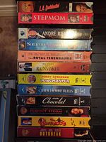 Left-hand stack of 12 VHS spines showing titles such as L.A. Confidential, Stepmom, André Rieu, etc.