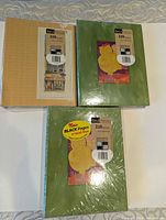Two green and one tan shrink-wrapped Gala Premium albums front view
