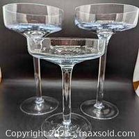 three clear glass stemmed pillar candle stands, varying heights