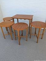 Front view showing rectangular table with four matching round nesting tables