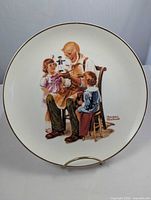 Front view of plate on stand showing Rockwell illustration and gold rim