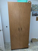 Front view of oak laminate cabinet with closed double doors