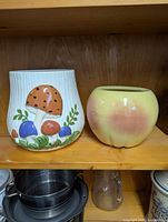 Both ceramic planters side by side on shelf