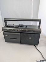 Front view showing Sony CFM-20 boombox, cassette deck, speaker, handle, antenna, power cord