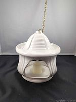 Front view of white ceramic pendant lamp showing ribbed design and candle inside