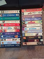 Two vertical stacks of VHS tapes in black storage racks