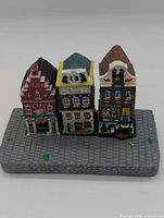 Front view of three canal house replicas on base