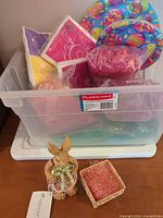 Overall lot showing tub, plates, napkins, filler, rabbit figurine and basket