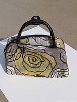 front view of floral embroidered handbag showing handles and pattern