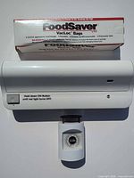 Front view showing vacuum sealer, VacLoc bag box, and kitchen scale