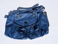 Front view showing color, braided flap, front pockets, handles, strap