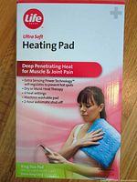 Front of retail box showing Life Ultra Soft Heating Pad, feature list, image of pad in use