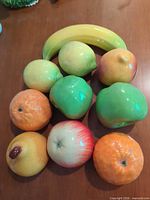 All ten ceramic fruit pieces arranged on tabletop