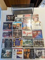 Overview of 20 CDs arranged in grid with metal rack above