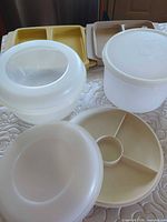 Group shot of all Tupperware pieces: divided round tray, domes, round storage container, rectangular party server pieces
