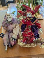Both porcelain clown figurines displayed side by side on table