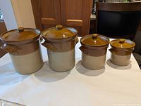 front view of all four stoneware canisters with lids