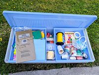 Open Rubbermaid storage box showing two drawer inserts filled with gift-wrap supplies