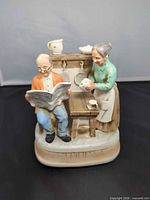 Front view showing elderly couple, table, shelf and overall scene on base