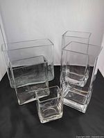All five clear glass vases grouped