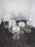 all seven glass canisters grouped showing size variation