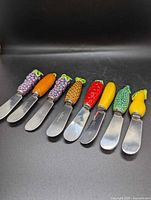 All eight spreaders displayed in a row showing handles and blades
