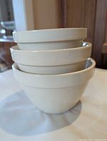 Three nested cream stoneware bowls stacked