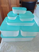 Stacked view of all teal-lidded containers showing size variety