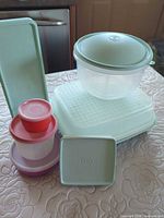 Group shot showing all Tupperware containers: round bowl, three snack cups, rectangular container and celery keeper