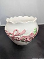 Front view showing scalloped rim and pink ribbon garland