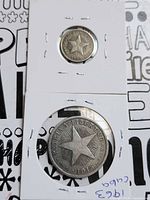 Two Cuban silver coins in cardboard flips, larger coin below, smaller above
